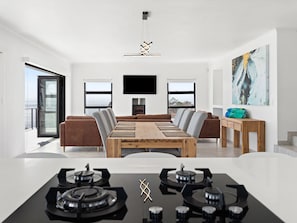 A modern living room with a dining area, a fireplace, and a large window with a view.