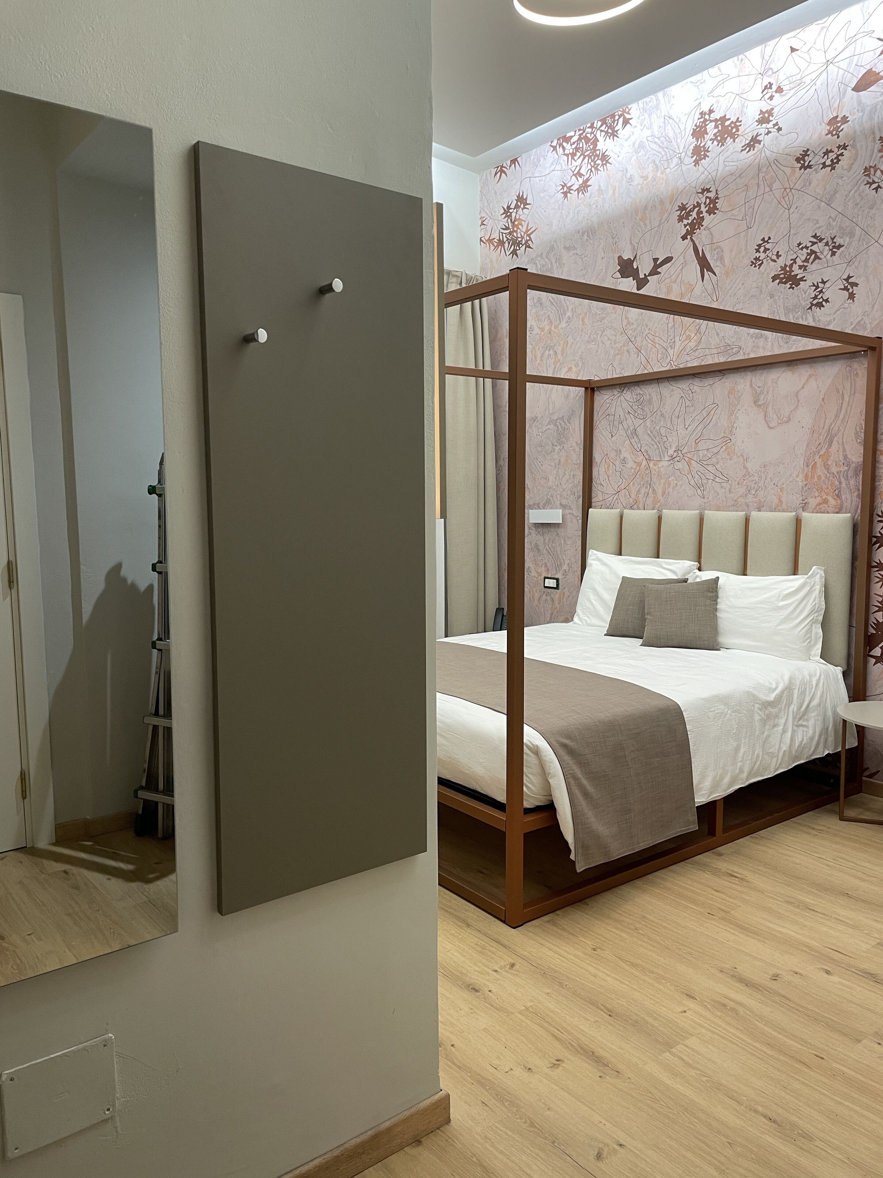 Um quarto com cama de dossel, um guarda-roupa e um espelho.
