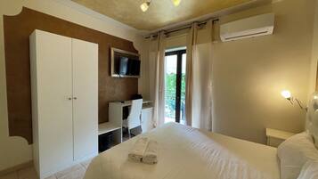 Une chambre à coucher comprenant un lit, un bureau, un téléviseur et un appareil de climatisation.