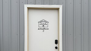 Une porte blanche avec une enseigne au-dessus indiquant : « Hideaway Inn, ancienne école de Waumanee, numéro 2 ».