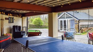 Ein Billardraum mit Pooltisch, Dartscheibe und grüner Spieltuchbedeckung.