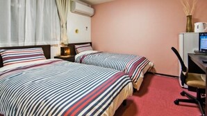 A hotel room with two beds, a desk, a chair, a computer, and a window with curtains. - Hotel Yuni Star-Club (Tokyo)