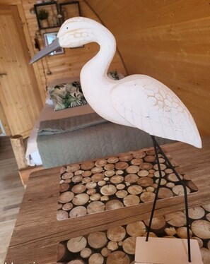 Ein Holztisch mit einer geschnitzten Vogelplastik, einem Holzstapel und einer kleinen Schachtel.