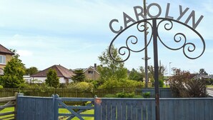 A metal sign with the name "CAROLYN" in a decorative font, mounted on a post with a simple crossbar. - 2 bedroom accommodation in Ellington, near Cresswell (Ellington, near Cresswell)