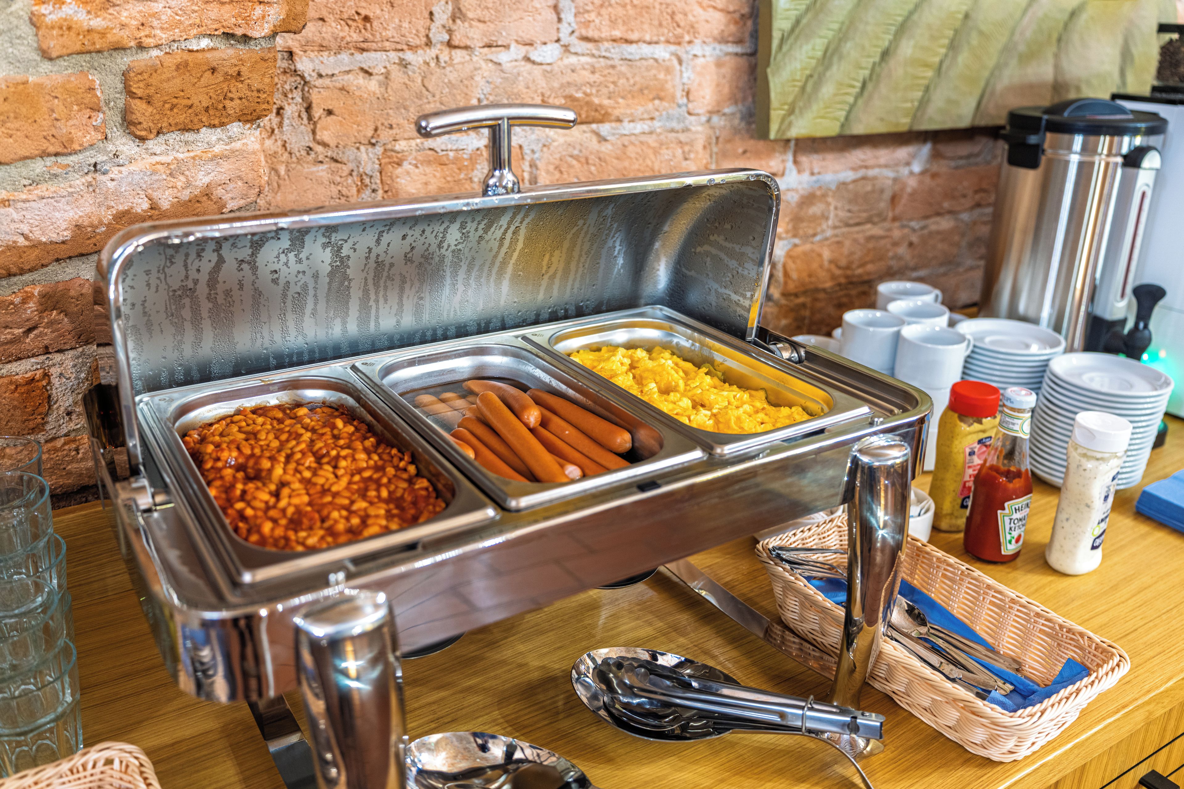 Un buffet proposant une variété de plats, d’ustensiles et de condiments.