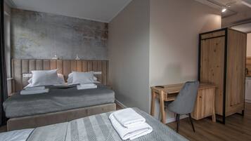 Una habitación de hotel moderna con dos camas, un escritorio y un armario.