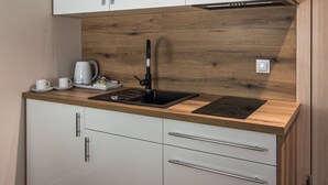 Une cuisine moderne avec des armoires blanches, un plan de travail en bois et un robinet noir.