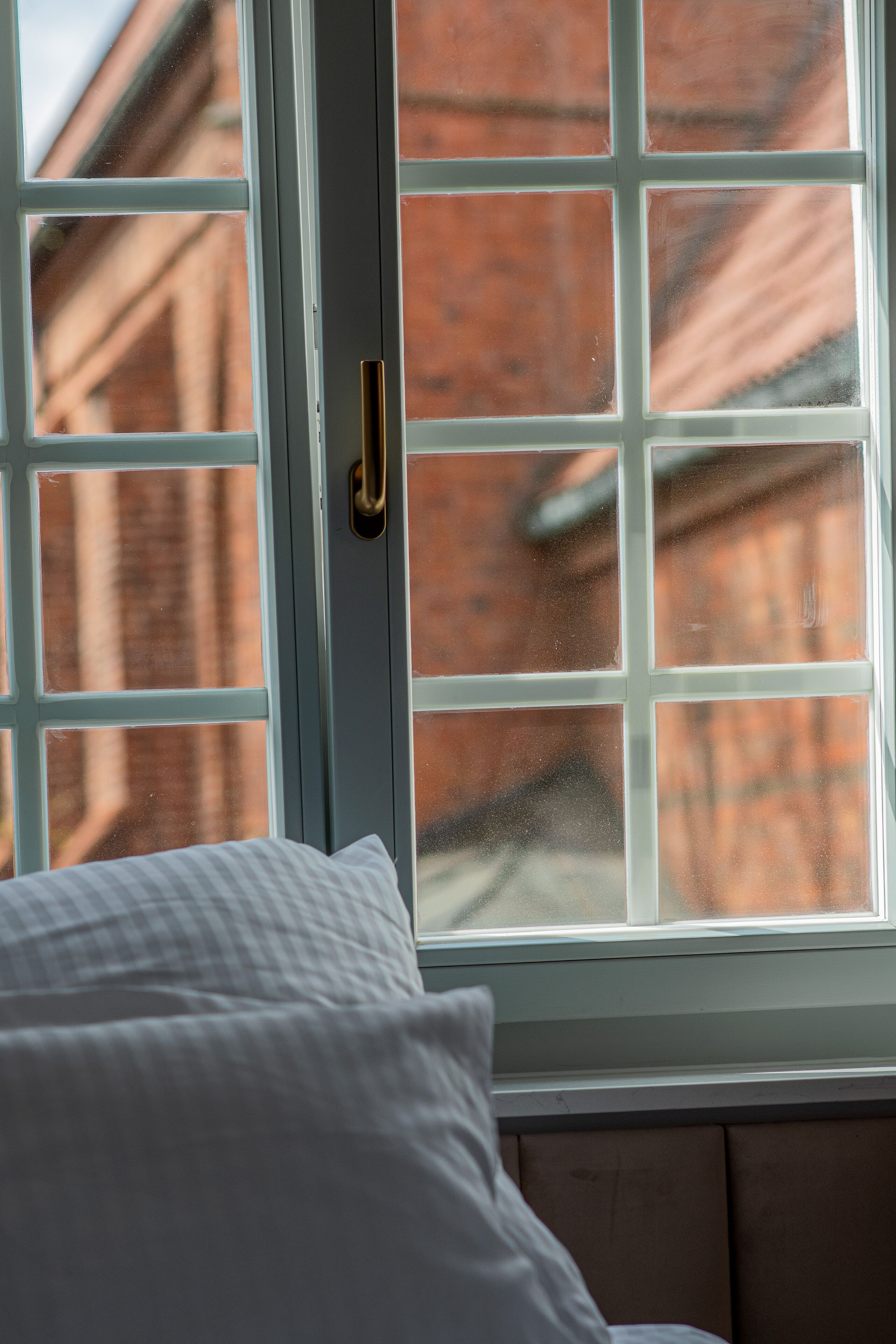 A window with a view of a brick building.