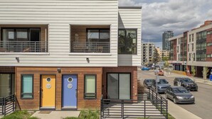 Ein modernes, mehrgeschossiges Gebäude mit flacher Fassade, großen Fenstern und einer Kombination aus Holz- und weißer Verkleidung.