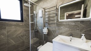 A modern bathroom with a glass-enclosed shower, a white toilet, and a sink with a mirror above it. - Deep blue 23 B&B (Magong)