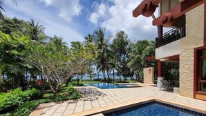 A pool area with tiled flooring, steps leading into the pool, and a view of the ocean. - Amatapura Beach Villa 12 (Krabi)