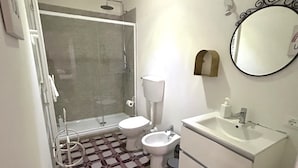A compact bathroom with a shower, toilet, bidet, and sink. - Loft with private bathroom (Arezzo)