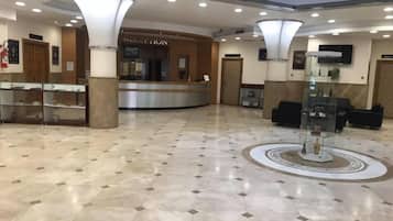 A spacious lobby with a reception desk, a reception area, and a seating area with sofas.