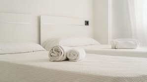 A hotel room with two beds, each with white linens and pillows, and a small bedside table. - V196| Villa Brisas - Four Bedroom Villa, Sleeps 8 (Torre Soli Nou)
