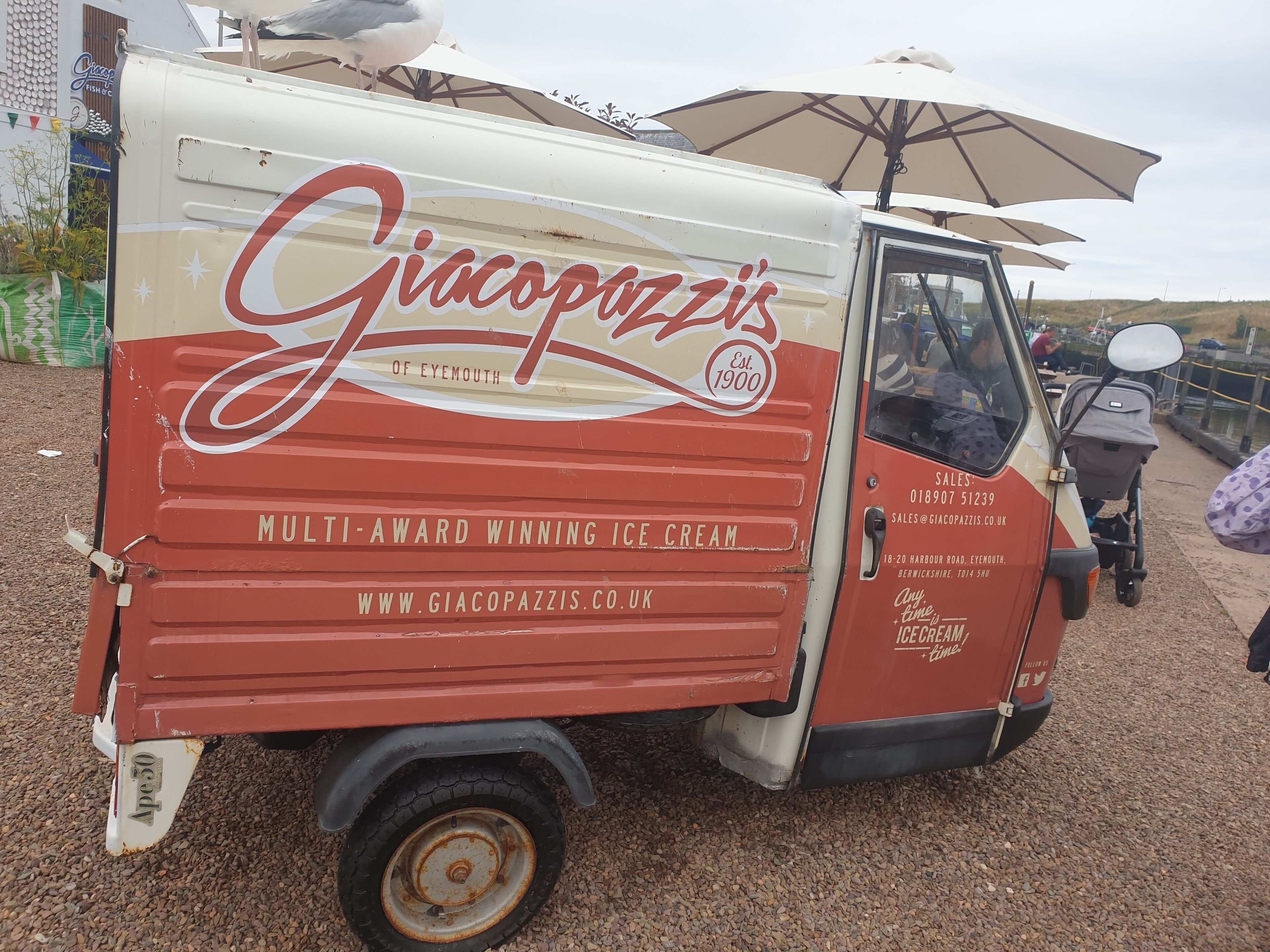 Un carrito de helados antiguo con la marca 'Giacopazzi' y el texto 'HELADO GALARDONADO CON MÚLTIPLES PREMIOS'.