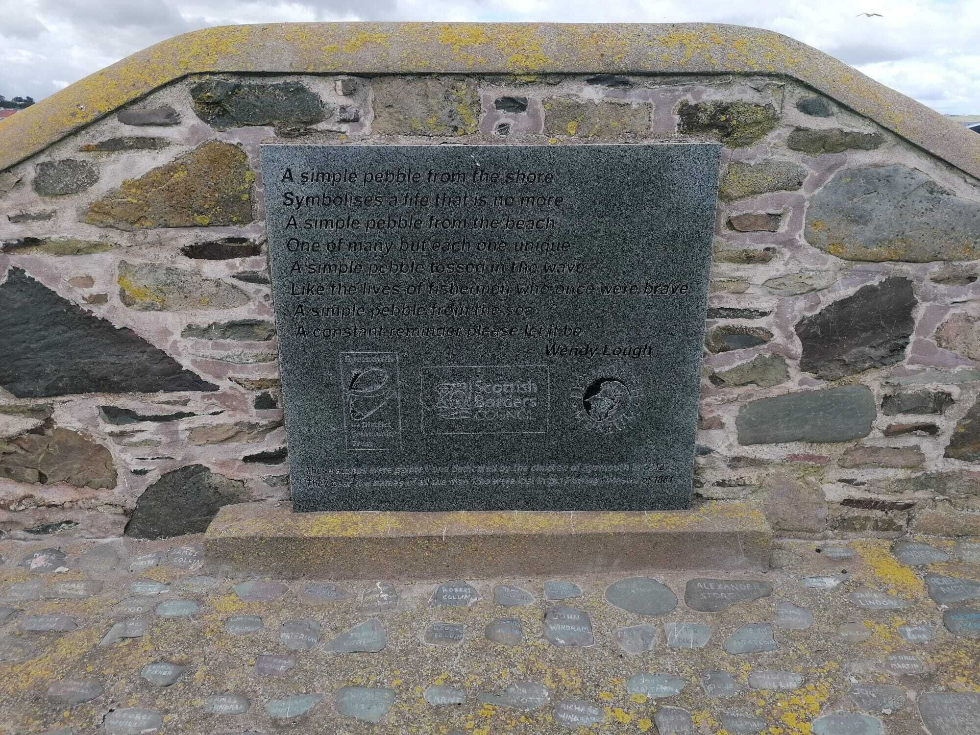 Un monumento de piedra con texto grabado y una placa.