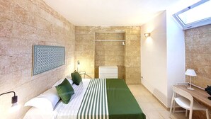 Een moderne hotelkamer met een bed, bureau en douche.