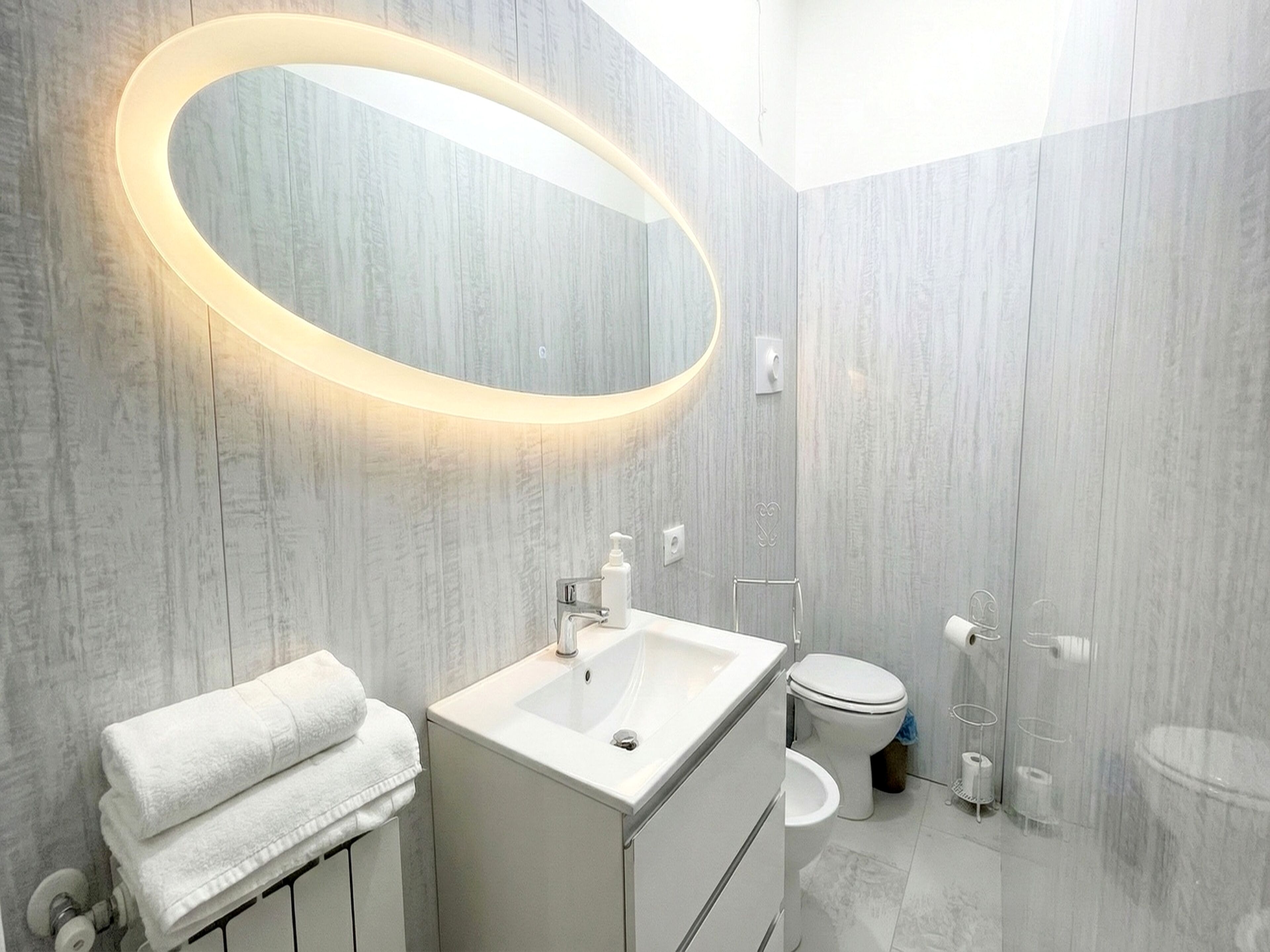 A modern bathroom with a vanity, a toilet, and a shower area.