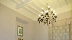 A bedroom with a large bed, a chandelier, a radiator, and a curtain with a polka dot pattern. - Junior Suite Deluxe per Due, Corso Italia 114 (Arezzo)