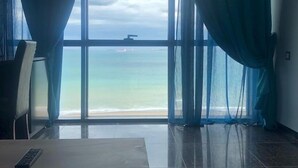 A room with a large window, a table, and a chair. - Syphax Tichy Plage (Tichy)