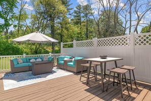 Une terrasse extérieure avec des meubles en osier, une table et des chaises.