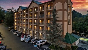 A multi-story hotel with a parking lot in front.