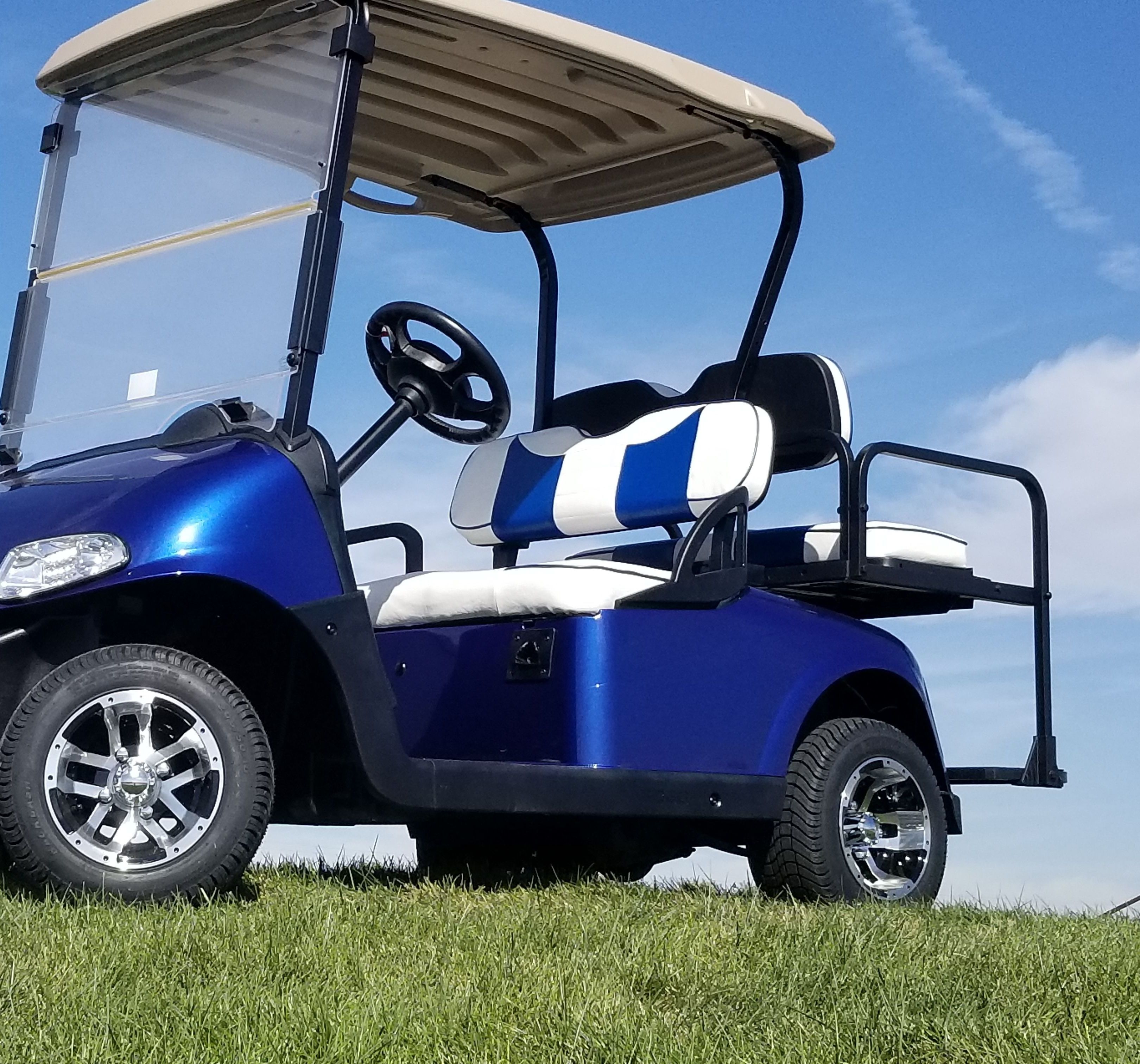 Une voiturette de golf avec un siège bleu et blanc, un toit et un volant.