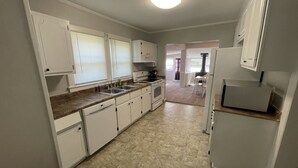 A kitchen with white cabinets, a dishwasher, a stove, and a refrigerator.