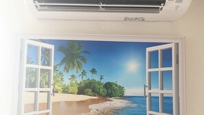 Aire acondicionado montado en la pared con una escena de playa tropical pintada debajo.