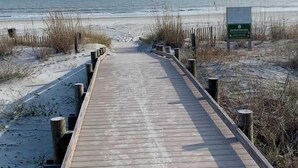 A wooden boardwalk leading to a beach with sand dunes and a clear sky. - Updated Beach Villa  2 bd 2 ba  just steps 2 sand! (Hilton Head Island)