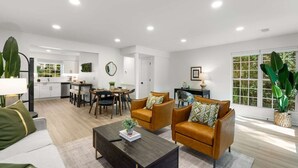 Una sala de estar moderna con sofá, mesa de centro y zona de comedor.