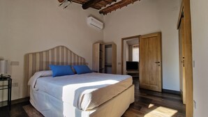 Une chambre à coucher comprenant un lit, une armoire, un téléviseur et un appareil de climatisation.