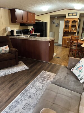 Cozy living space with a central kitchen, dining area, and comfortable seating.