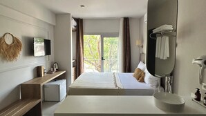 A modern hotel room with a large bed, a built-in desk, a flat-screen TV, a large mirror, and a view of the outdoors. - Mumu Bodrum Hotel (Bodrum)