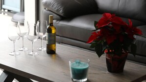 A table with a bottle of wine, several glasses, a candle, and a potted plant. - Gîte L'angélique - Fleurs des Pyrénées - Vue Hautacam (Argelès-Gazost)