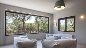 A modern room with large windows, a sofa, and a hanging light fixture. - Villa Opuntia - Sirens Avenue (Pula)