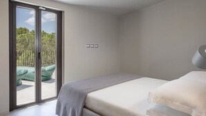 A bedroom with a bed, a sliding glass door leading to an outdoor seating area, and a ceiling light fixture. - Villa Opuntia - Sirens Avenue (Pula)