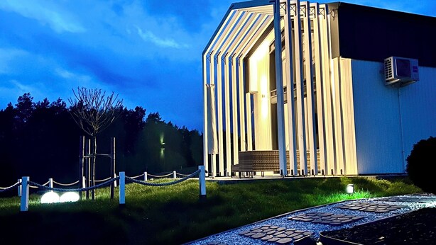 Um edifício moderno com design arquitetônico único, caracterizado por linhas verticais e um telhado inclinado.