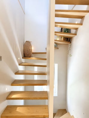 A modern staircase with wooden steps and a glass railing.