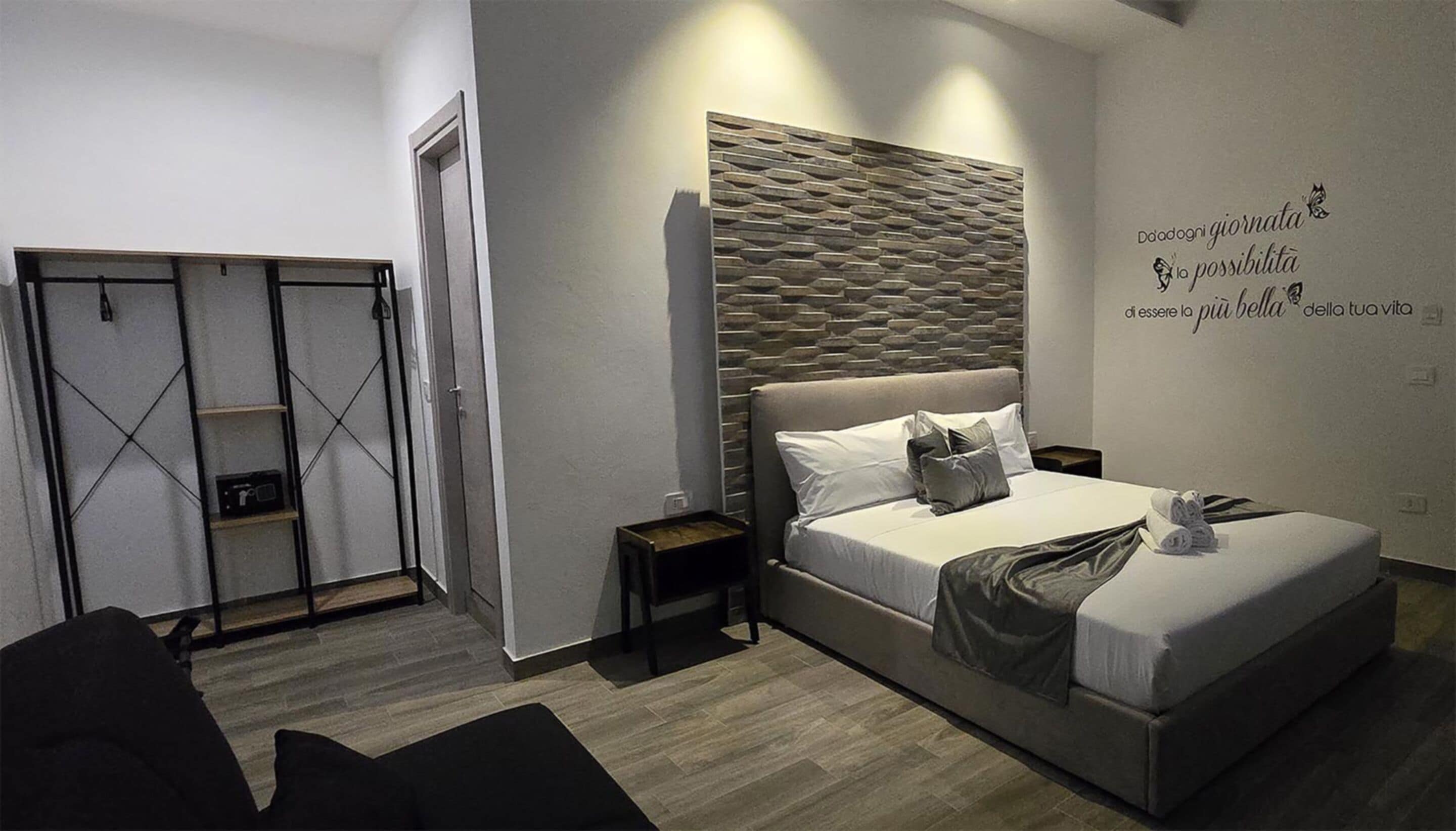 Un dormitorio moderno con una cama, un armario y una pared con texto motivacional.