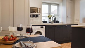 A modern kitchen with a dining area, including a table set for two with wine glasses and a plate of food. - 3 bedroom accommodation in Easington, near Staithes (Easington, near Staithes)