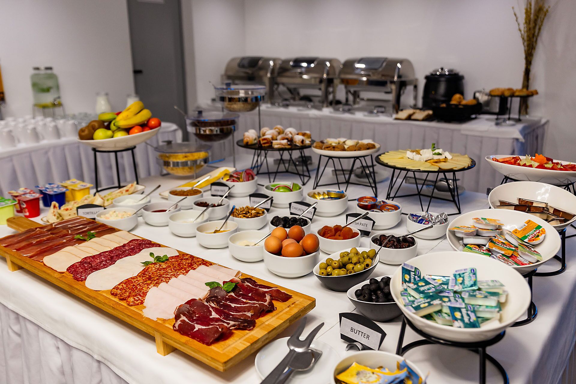 A buffet table with various food items and condiments.