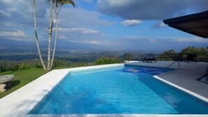 Una piscina rectangular con una vista despejada del paisaje de fondo.