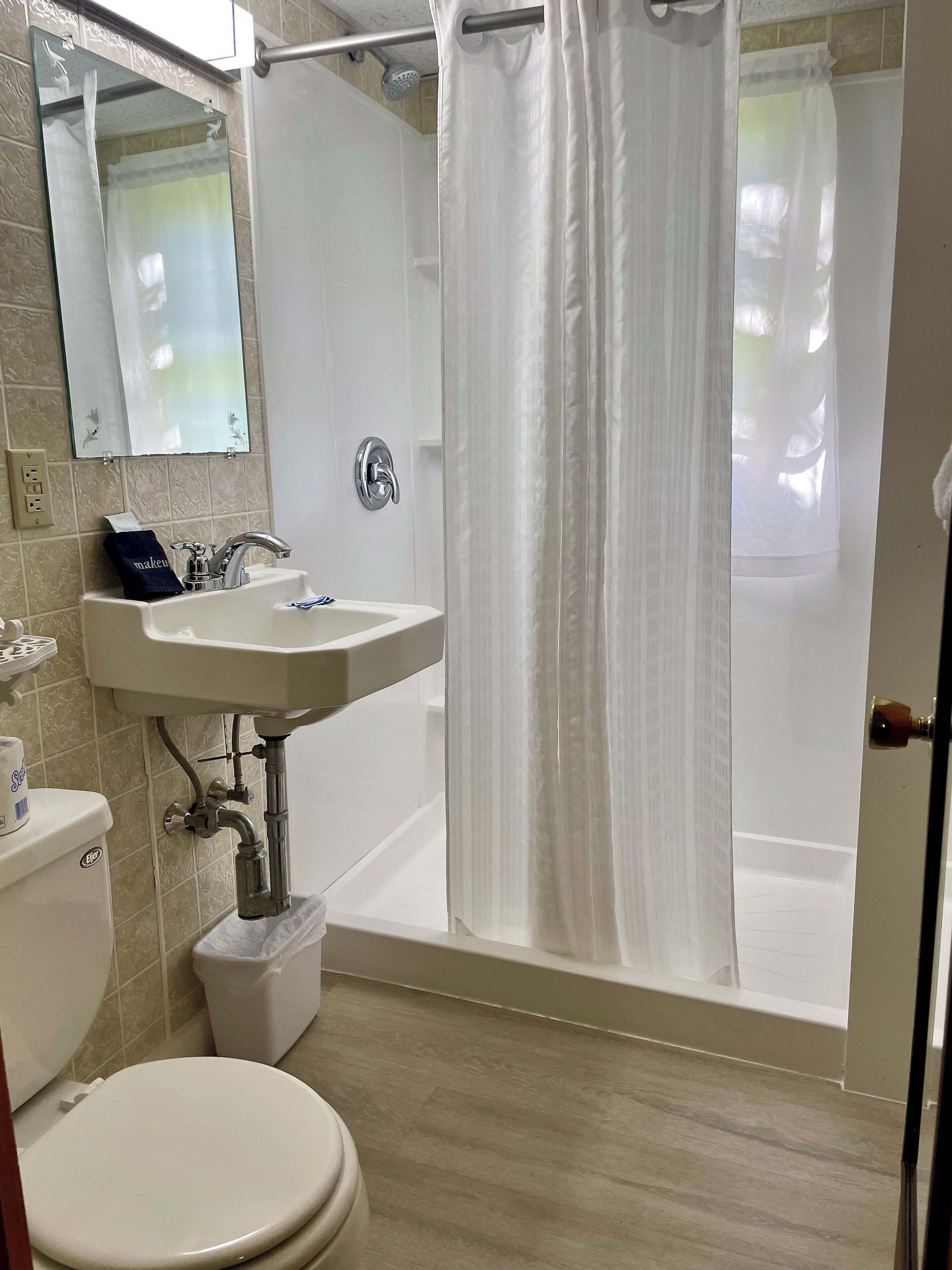 Un baño con inodoro, lavabo y ducha.