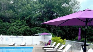 A swimming pool with lounge chairs and a covered seating area. - Kennebunkport Motor Lodge (Kennebunkport)