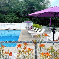 Una piscina al aire libre de temporada, sombrillas