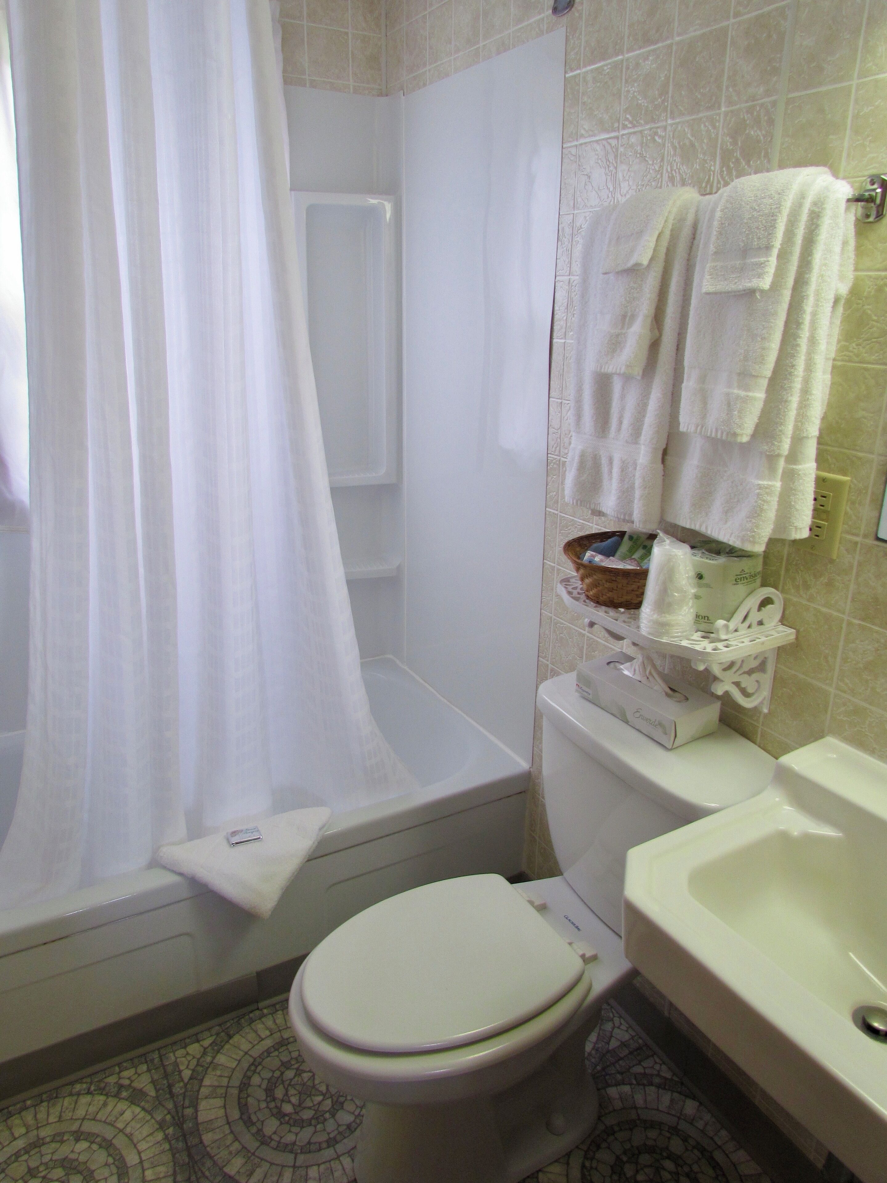 A bathroom with a bathtub, toilet, and sink.