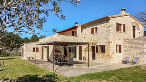 A stone house with a covered patio, outdoor furniture, and a garden. - Stunning home in Condillac (Condillac)
