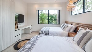 A modern bedroom with two beds, a TV, and a large window.