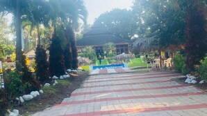 A paved pathway leading to a building with a sign indicating a restaurant. - Brisas de los Alpes (Jarabacoa)